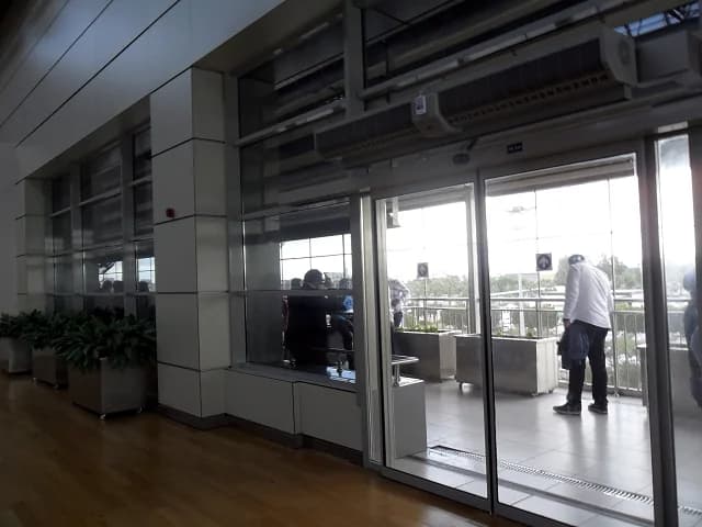 View towards an outdoor airport smoking terrace through glass doors