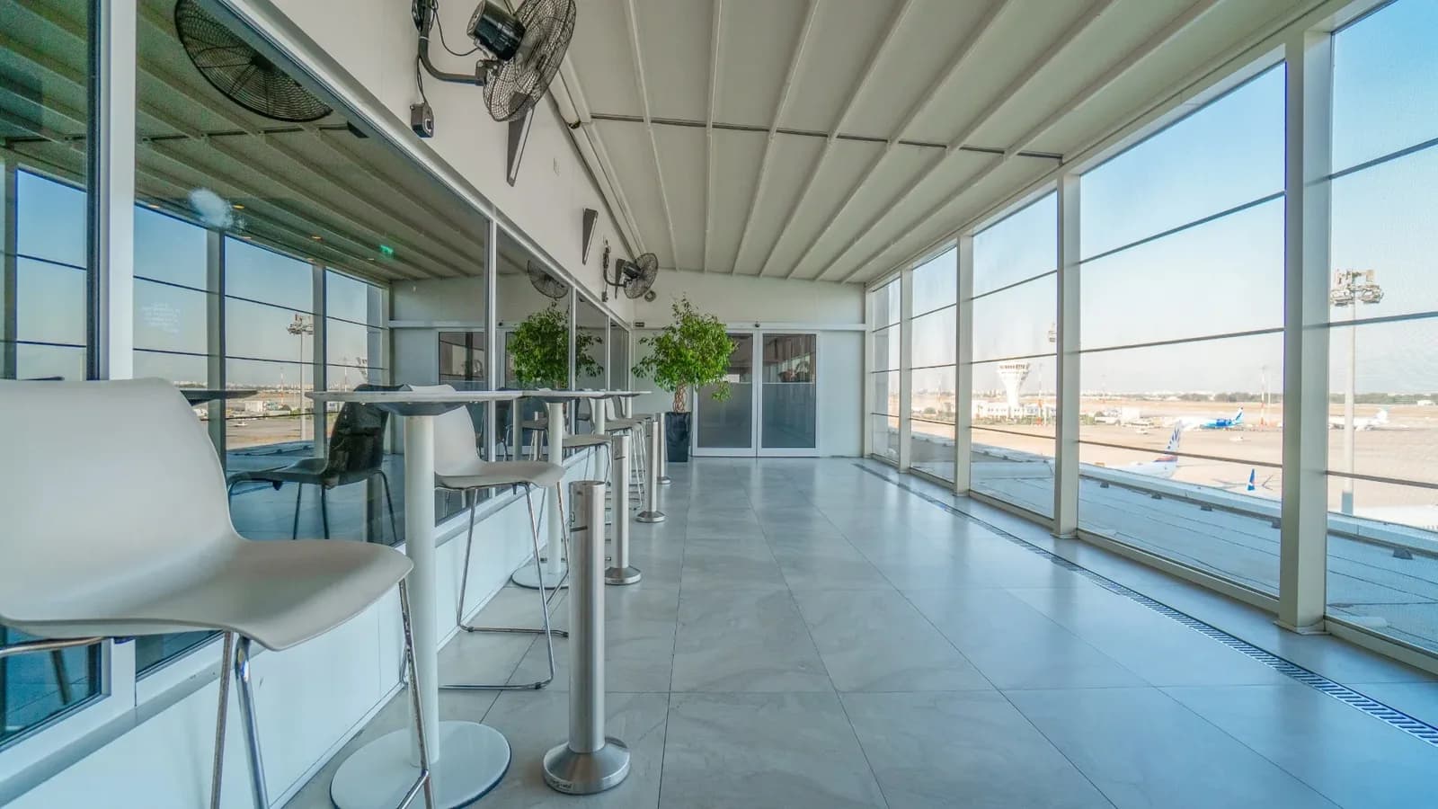 Airport smoking terrace with tables and runway view